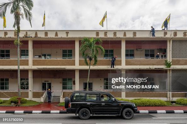 Brunei Postcode A vehicle drives past workers cleaning Brunei's main Post Office ...