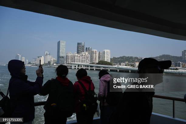Chinese tourists look at the waterfront of Xiamen, in China's southeast Fujian province at the start of a boat tour to view Taiwanese islands from a...