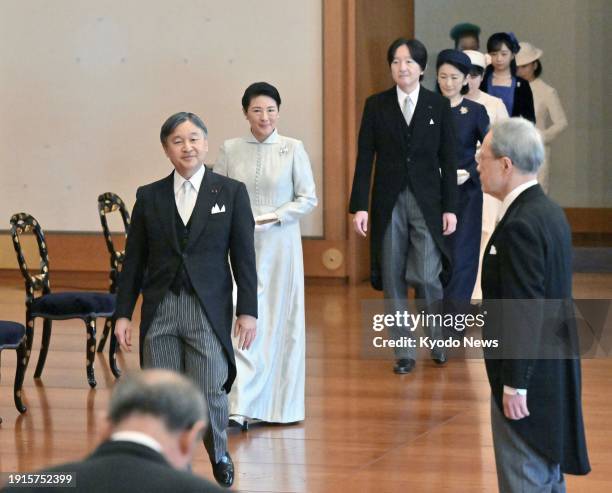 Japanese Emperor Naruhito, Empress Masako and other imperial family members enter the Matsu-no-Ma stateroom at the Imperial Palace in Tokyo for the...