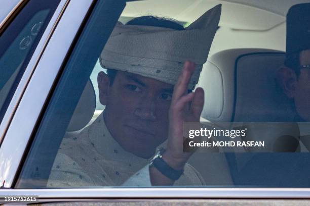 Brunei's Prince Abdul Mateen waves from his car as he leaves following his solemnization as part of the royal wedding at Sultan Omar Ali Saifuddien...