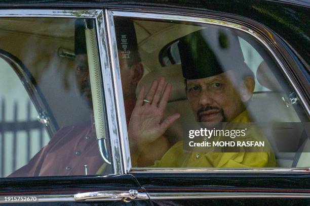 Brunei's Sultan Hassanal Bolkiah waves as he arrives for his son Prince Abdul Mateen's solemnization ceremony as part of the royal wedding at Sultan...