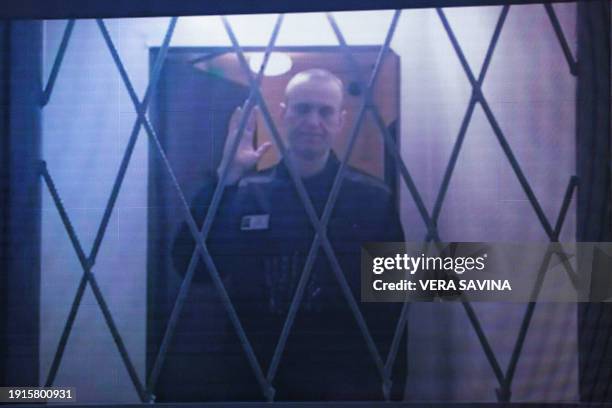 Jailed Russian opposition figure Alexei Navalny is seen on a screen via a video link from the IK-3 penal colony above the Arctic circle during a...