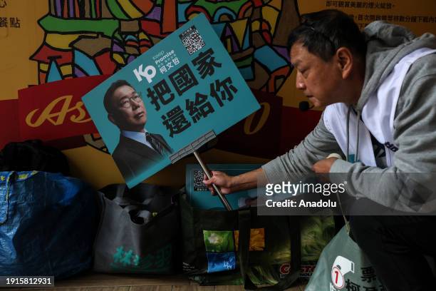 Supporter holds a banner featuring Taiwan People's party presidential candidate Ko Wen-je as daily life continues ahead of general election in...