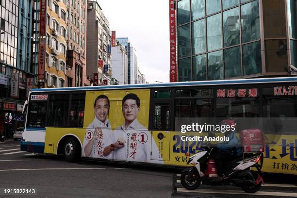 Campaign billboard featuring Kuomintang presidential candidate Hou You-yi and vice-presidential candidate Jaw Shau-kong is seen on a bus as daily...