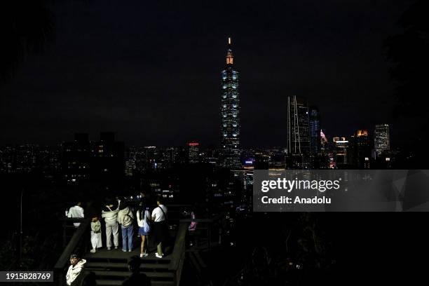 Visitors take pictures of the city from a lookout on the Xiangshan hiking trail as daily life continues ahead of general election in Taipei, Taiwan...