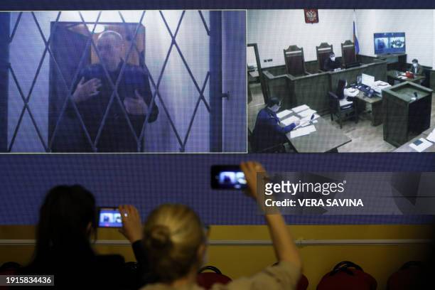 Jailed Russian opposition figure Alexei Navalny is seen on a screen via a video link from the IK-3 penal colony above the Arctic circle during a...