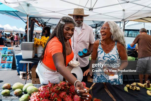afroamerikanisches seniorenpaar mit lokalem reiseleiter auf dem bauernmarkt von hawaii - bauernmarkt stock-fotos und bilder