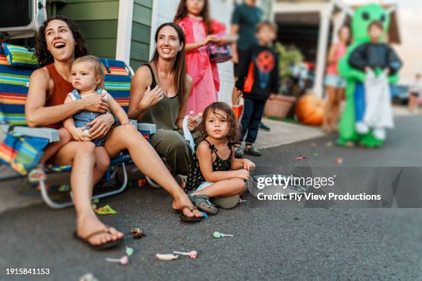 friends with children celebrating halloween at neighborhood block party parade - straatfeest stockfoto's en -beelden