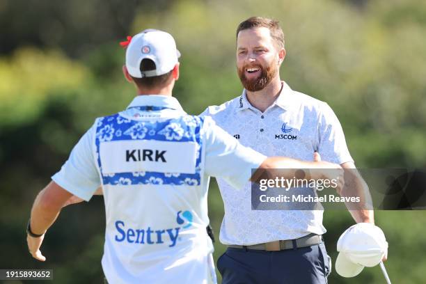 Chris Kirk of the United States celebrates with caddie Michael Cromie after winning on the 18th green during the final round of The Sentry at...