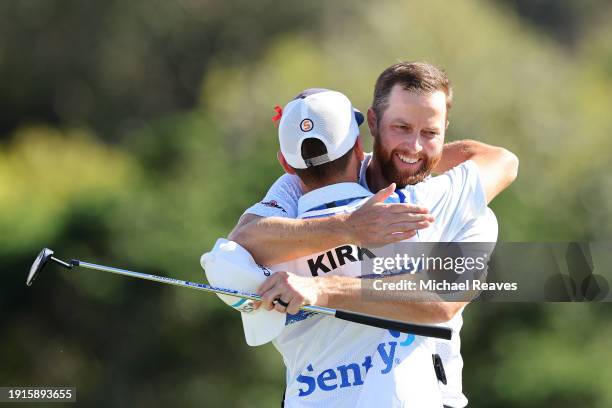 Chris Kirk of the United States celebrates with caddie Michael Cromie after winning on the 18th green during the final round of The Sentry at...