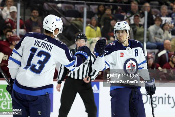 Mark Scheifele of the Winnipeg Jets celebrates with teammate Gabriel Vilardi after scoring an empty net goal against the Arizona Coyotes during the...