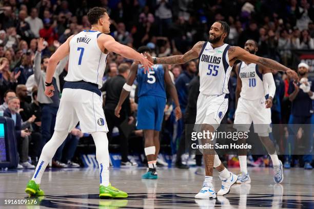 Derrick Jones Jr. #55 of the Dallas Mavericks is congratulated by Dwight Powell after dunking the ball during the second half against the Minnesota...