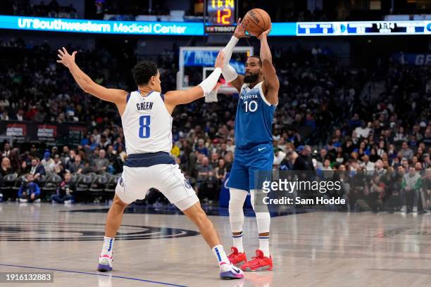 Mike Conley of the Minnesota Timberwolves looks to pass as Josh Green of the Dallas Mavericks defends during the second half at American Airlines...