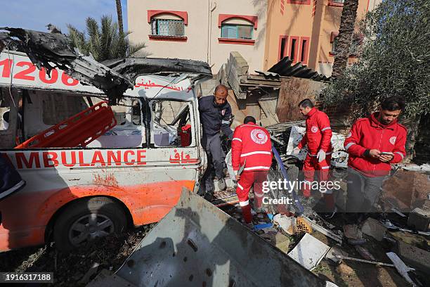 Palestinian Red Crescent personnel check a destroyed ambulance in Deir al-Balah in the central Gaza Strip, on January 11 amid the ongoing conflict...