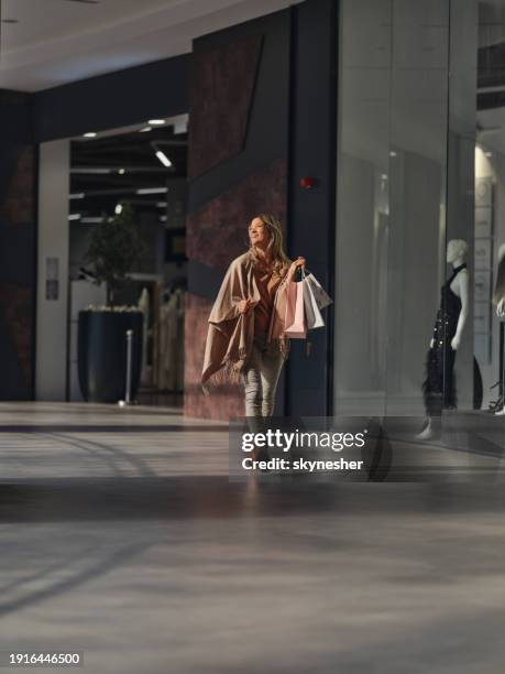 happy woman enjoying while walking through a shopping mall. - consumer store stock pictures, royalty-free photos & images