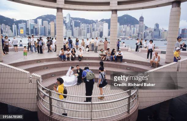 Couple pose for wedding portraits overlooking Hong Kong harbour on the eve of the handover of sovereignty from Britain to China, on 30th June 1997,...