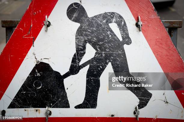 Detail of the scratched surface of a 'Men At Work' roadworks street sign on Piccadilly in the West End, on 5th January 2024, in London, England.