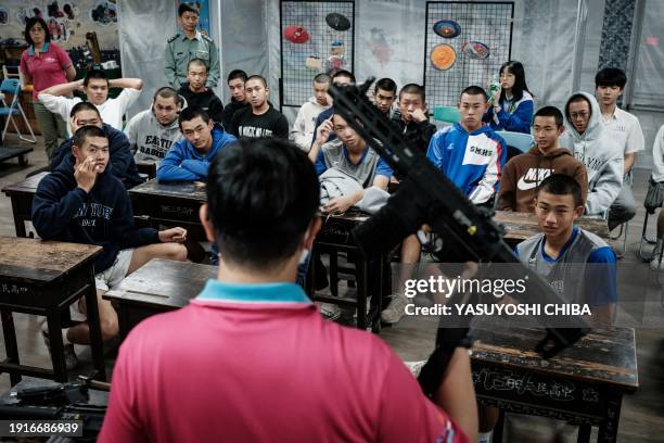 Students listen to a Taiwanese military instructor before their shooting training with airsoft rifles and guns at Kaohsiung Municipal Sanmin Senior...