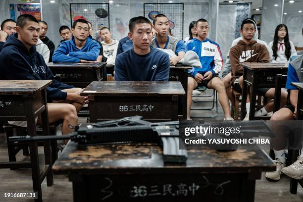 Students listen to a Taiwanese military instructor before their shooting training with airsoft rifles and guns at Kaohsiung Municipal Sanmin Senior...