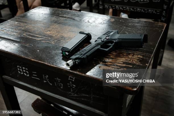 An airsoft gun is placed on a desk as a Taiwanese military instructor briefs students before their shooting training at Kaohsiung Municipal Sanmin...