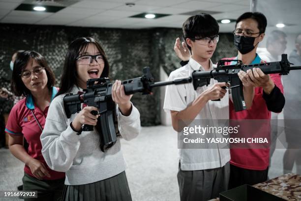 Students learn how to use an airsoft gun from Taiwanese military instructors at Kaohsiung Municipal Sanmin Senior High School in Kaohsiung on January...