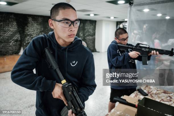 Students learn how to use airsoft rifles at Kaohsiung Municipal Sanmin Senior High School in Kaohsiung on January 11, 2024. Kaohsiung City launched a...