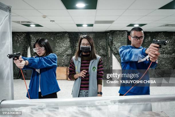 Students learn how to use an airsoft gun from a Taiwanese military instructor at Kaohsiung Municipal Sanmin Senior High School in Kaohsiung on...