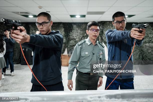 Students learn how to use an airsoft gun from a Taiwanese military instructor at Kaohsiung Municipal Sanmin Senior High School in Kaohsiung on...