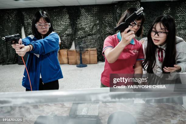 Students learn how to use an airsoft gun from a Taiwanese military instructor at Kaohsiung Municipal Sanmin Senior High School in Kaohsiung on...