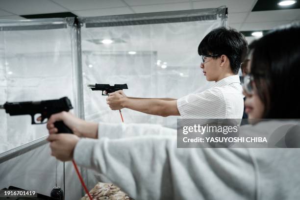 Students learn how to use an airsoft gun from a Taiwanese military instructor at Kaohsiung Municipal Sanmin Senior High School in Kaohsiung on...