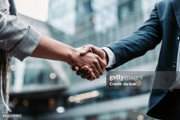 meeting success. two business persons shaking hands standing outside - handshake bildbanksfoton och bilder