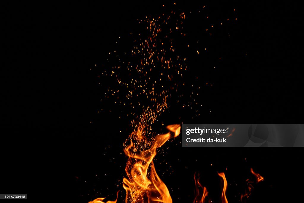 Burning fire with sparks on black background
