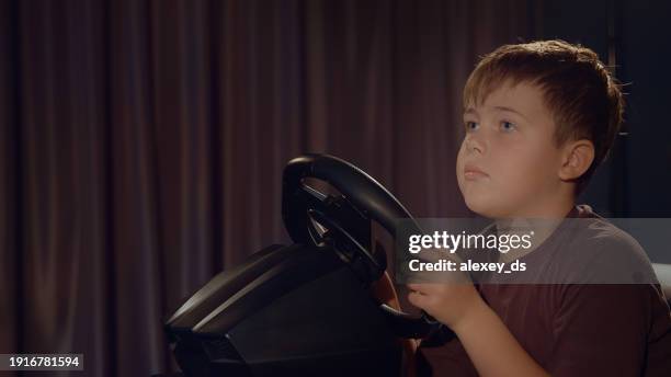 close-up of a blonde boy holding a gaming wheel - car racing video game stock pictures, royalty-free photos & images