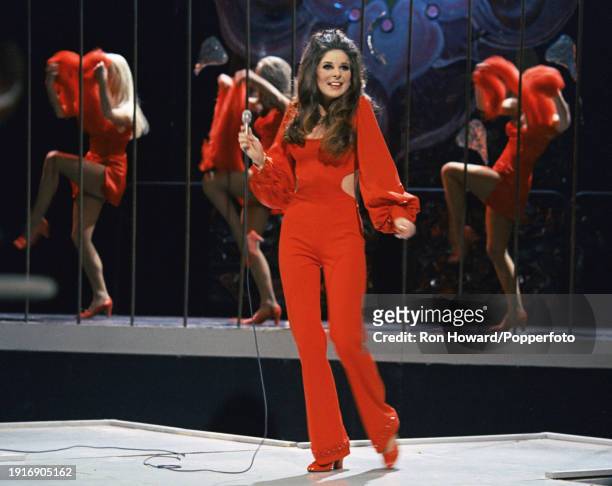 American singer Bobbie Gentry performs with, behind, backing dancers, on the set of a pop music television show in London circa 1970.