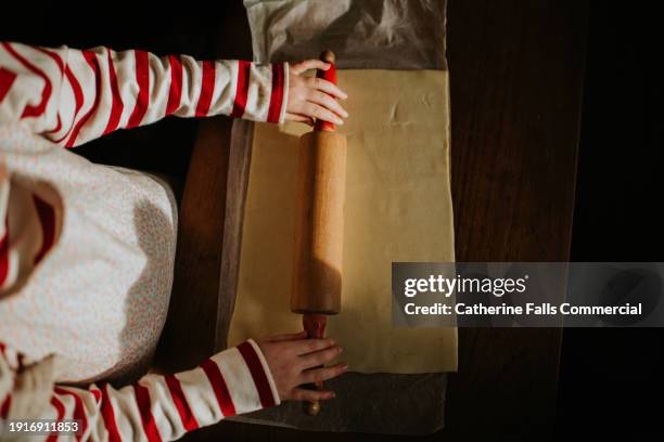 child rolls out pastry with a wooden rolling pin - shortcrust pastry stock pictures, royalty-free photos & images