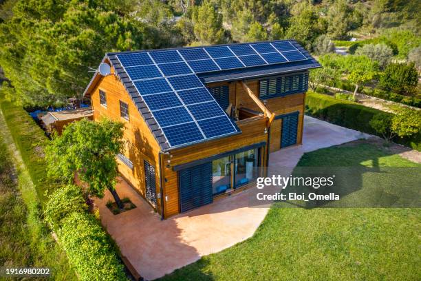 panneaux solaires photovoltaïques sur le toit d’une maison en bois - maison photos et images de collection
