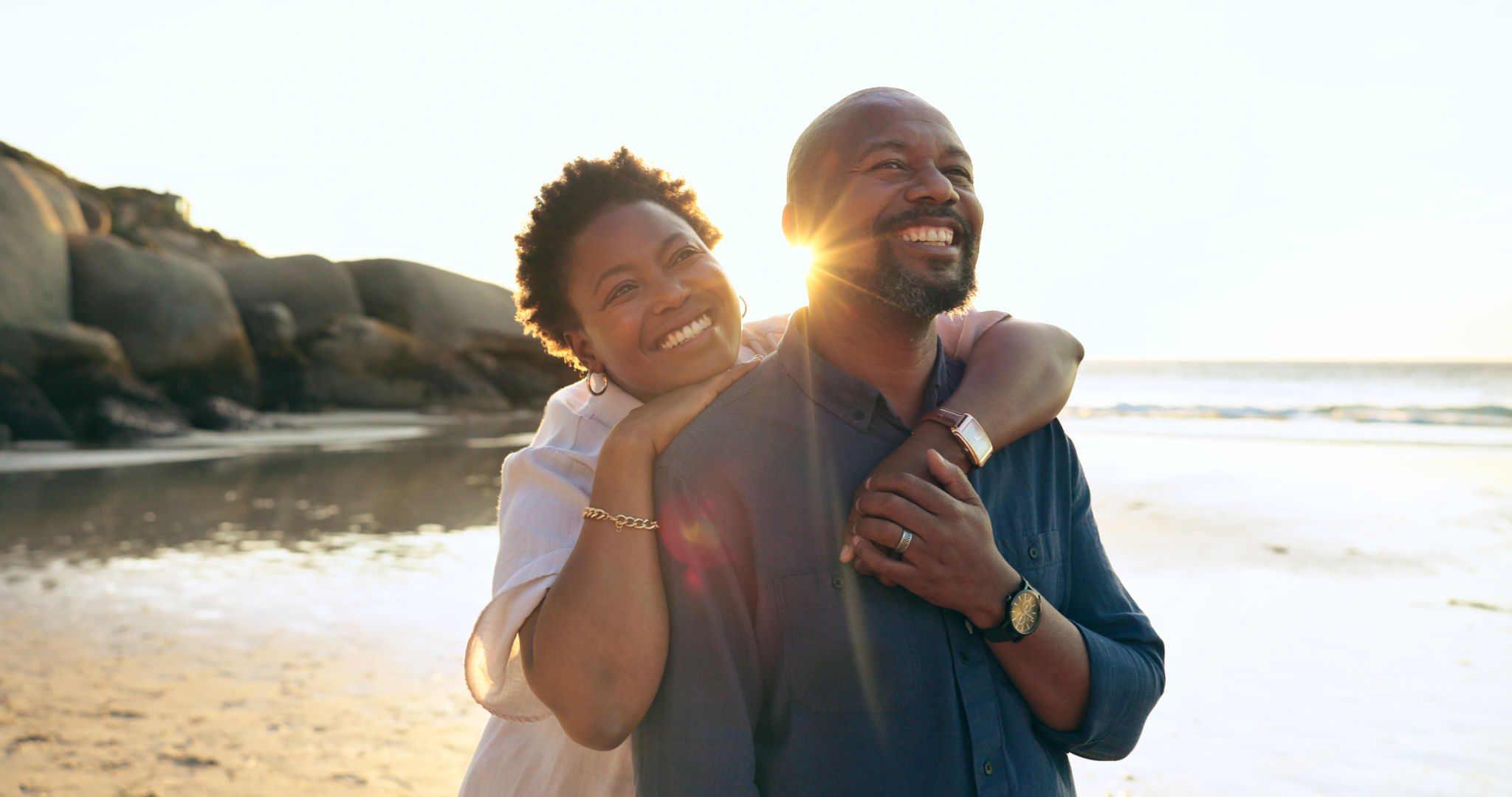Couple, hug and happy on beach with love, bonding and sunset for holiday, vacation and relationship. Black people, man or woman with embrace, smile and romance by ocean or sea for travel or adventure Couple, hug and happy on beach with love, bonding and sunset for holiday, vacation and relationship. Black people, man or woman with embrace, smile and romance by ocean or sea for travel or adventure