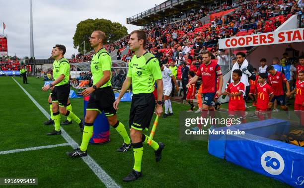 Referees lead te teams out during the A-League Men round 12 match between Adelaide United and Macarthur FC at Coopers Stadium, on January 08 in...