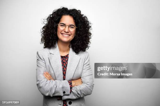 beautiful woman with arms crossed against white background - affärskvinna bildbanksfoton och bilder