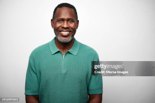 mature businessman smiling over white background - tête composition photos et images de collection