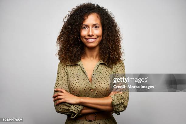 smiling multiracial businesswoman with arms crossed - dominikanischer abstammung stock-fotos und bilder