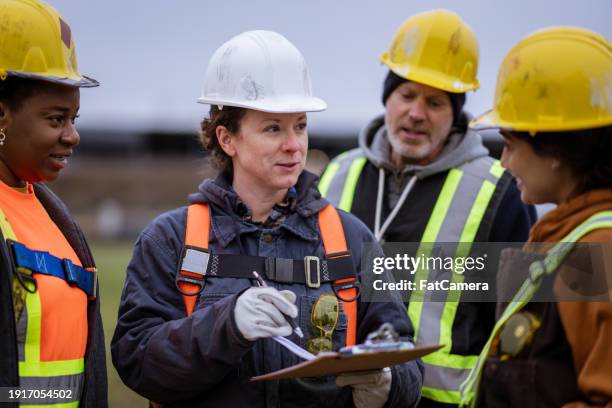 labourers planning on site - sicherheitsgurt sicherheitsausrüstung stock-fotos und bilder