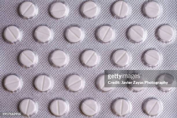 tablets in a blister isolated on yellow background - blister pack stock-fotos und bilder