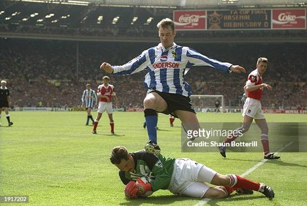 John Sheridan of Sheffield Wednesday leaps over goalkeeper David Seaman of Arsenal during the FA Cup final at Wembley Stadium in London. The match...