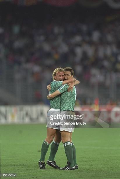 Andreas Brehme and Klaus Augenthaler of West Germany embrace after their victory in the World Cup semi-final against England at the Delle Alpi...