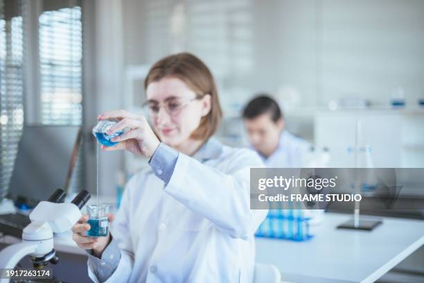 in the cutting-edge laboratory, scientists conducted a groundbreaking experiment involving the precise manipulation of various chemicals and experimental substances, all while clad in specialized grounding suits. this innovative endeavor aimed to advance - conducted stock pictures, royalty-free photos & images