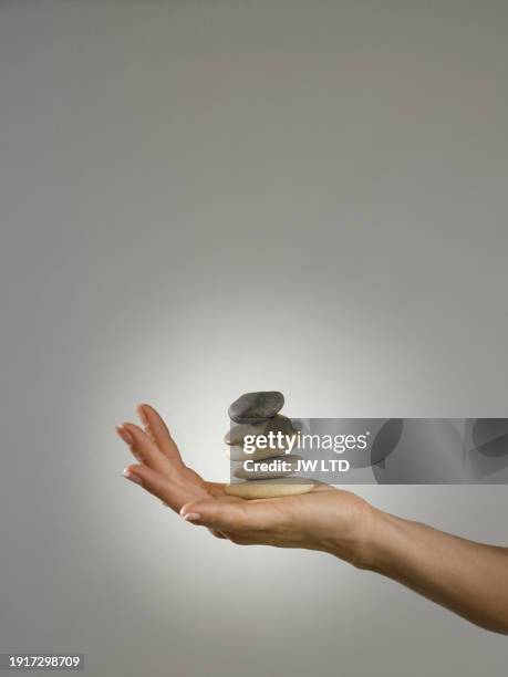 caucasian woman balancing  rocks in palm - hands sun stock pictures, royalty-free photos & images