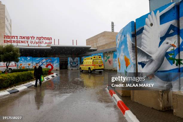 Man walks past murals outside the Ziv Hospital in the northern Israeli city of Safed on January 11 amid increasing cross-border tensions with...