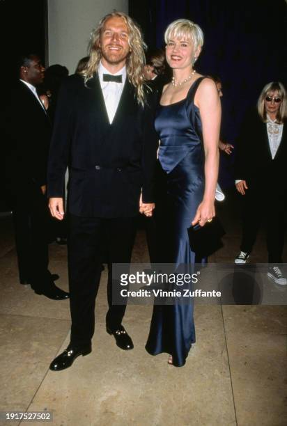 Finnish film director Renny Harlin, wearing a tuxedo and bow tie, and his wife, American actress Geena Davis, who wears a dark blue evening gown,...