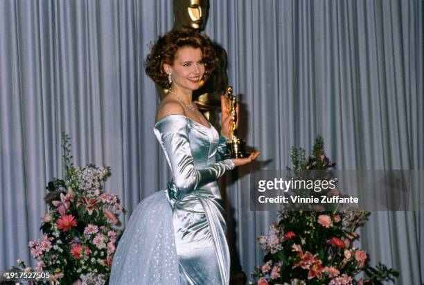 American actress Geena Davis wearing an off-shoulder blue evening gown, in the press room of the 61st Academy Awards, held at the Shrine Auditorium...